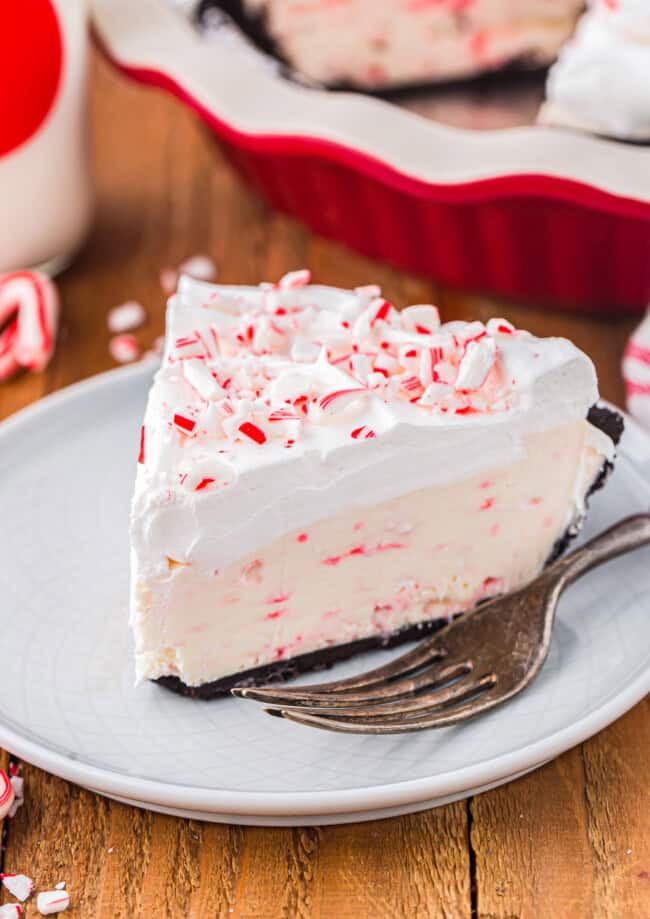 a slice of peppermint pie on a white plate with a fork.