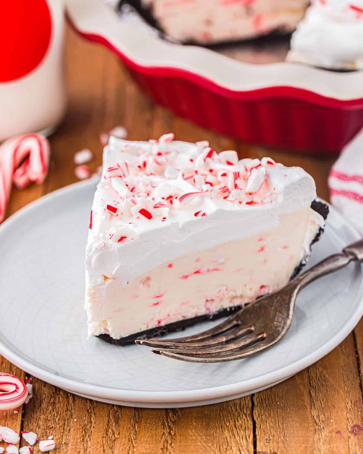 a slice of peppermint pie on a white plate with a fork.