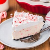 a slice of peppermint pie on a white plate with a fork.