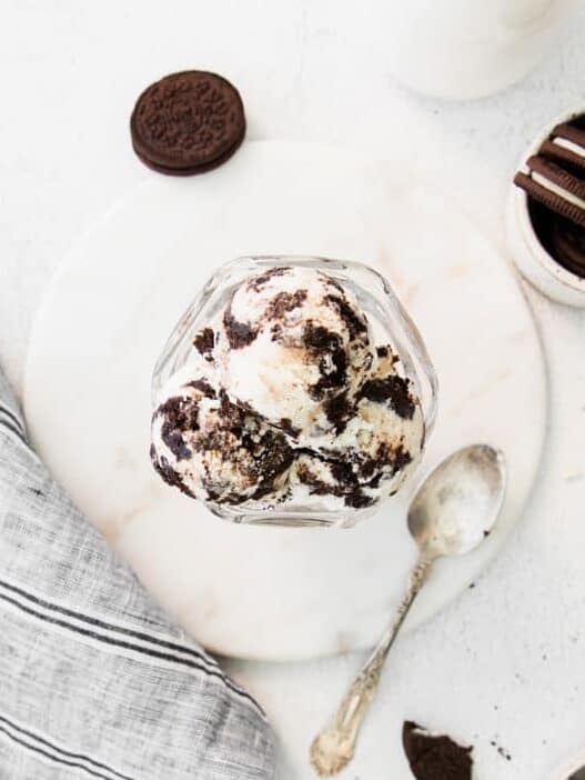 overhead view of oreo ice cream in a glass dish with a spoon.