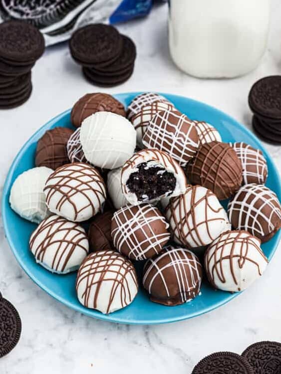 a plate of oreo truffles on a table with a glass of milk and a package of Oreo cookies