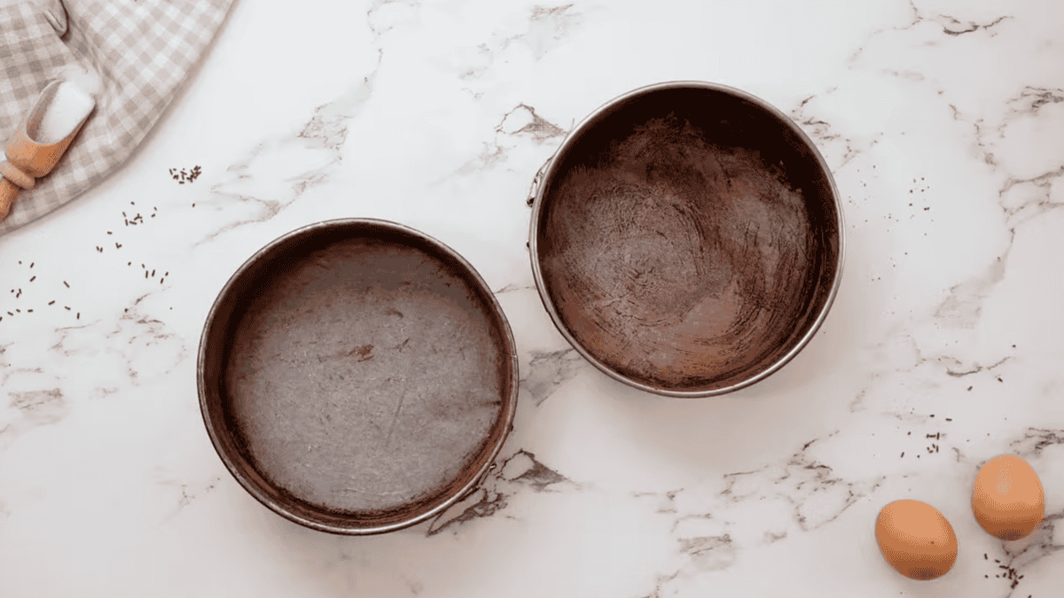 2 lined round cake pans dusted with cocoa powder.