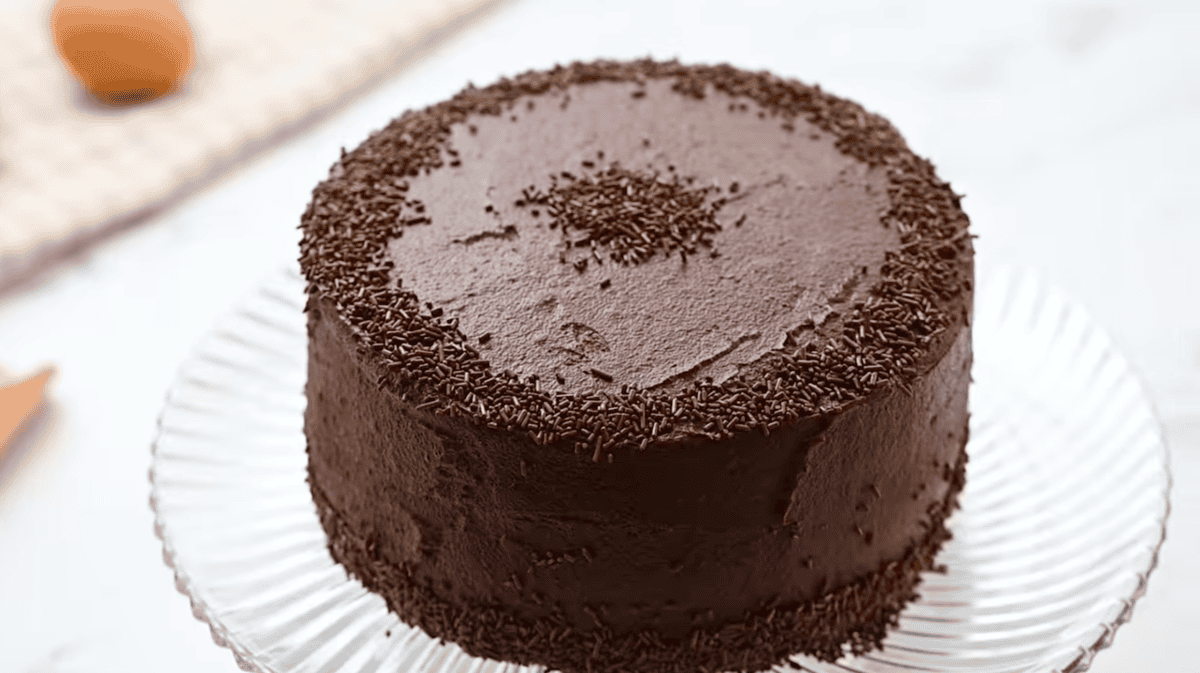 frosted devil's food cake on a cake stand.