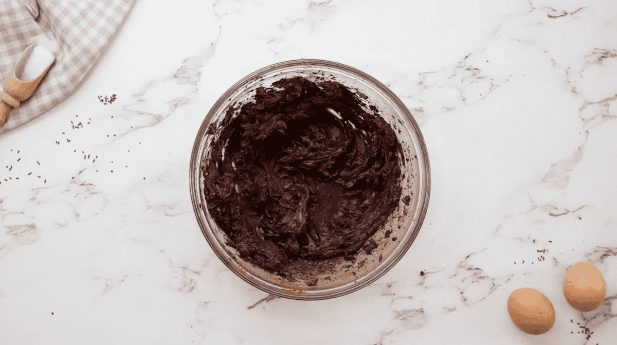 creamed butter and cocoa powder in a glass bowl.