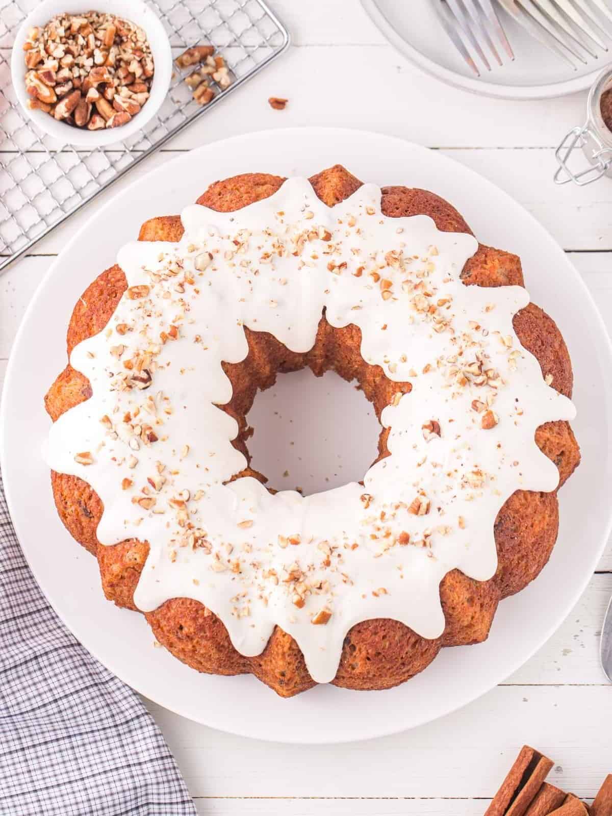 overhead view of carrot bundt cake on a white cake plate.