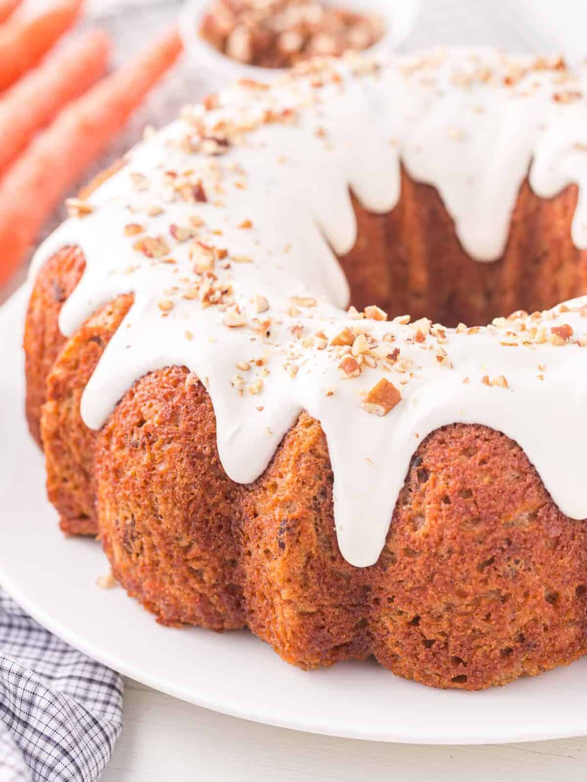 three-quarters view of carrot bundt cake on a white cake plate.