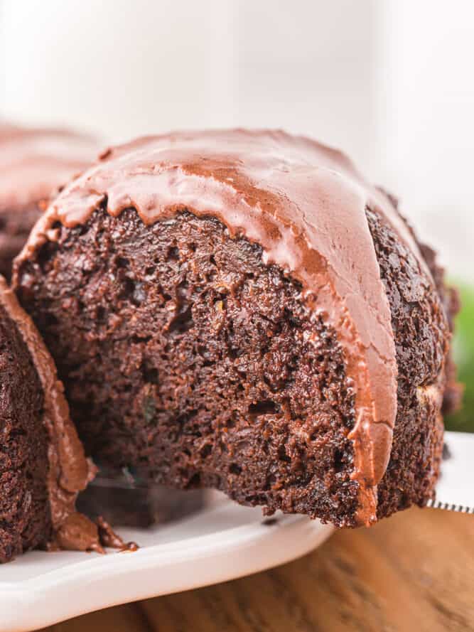 a large slice being removed from chocolate zucchini bundt cake.