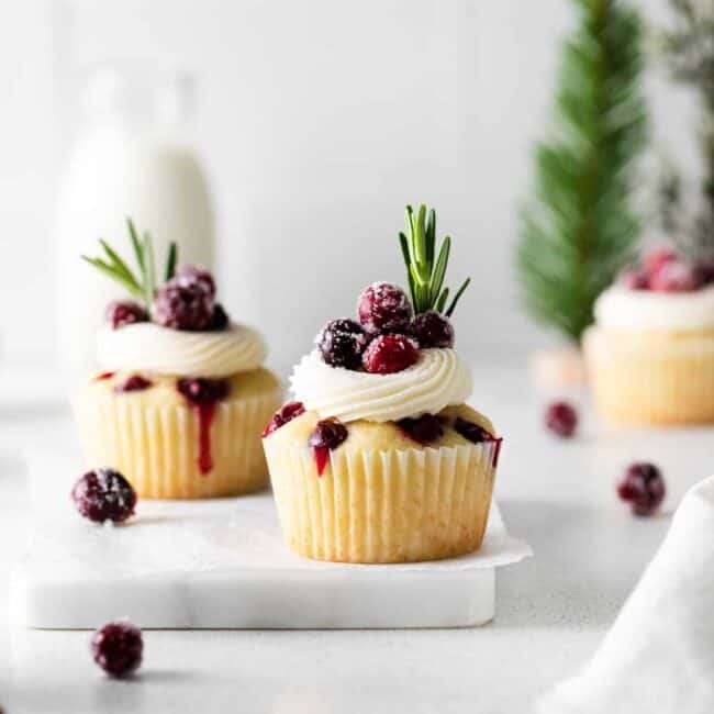 cranberry cupcakes with whipped cream and cranberries.