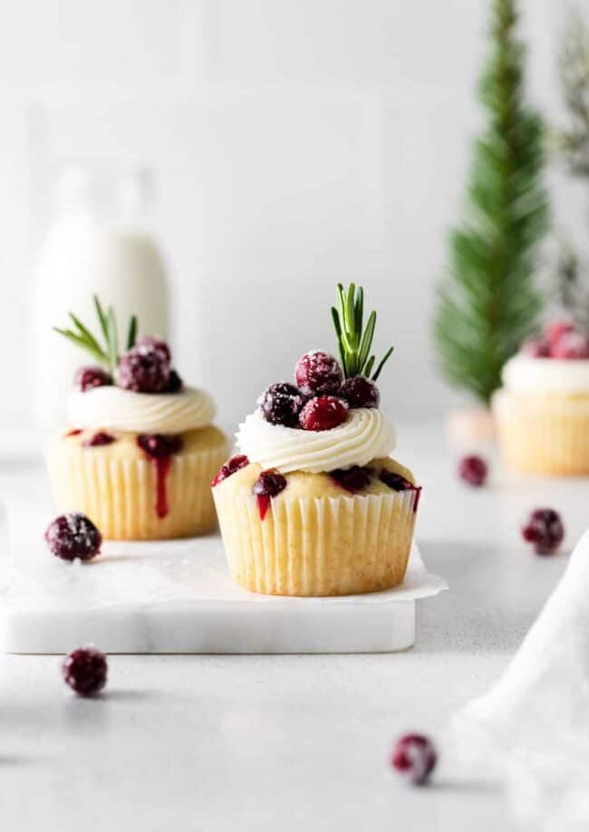 cranberry cupcakes with whipped cream and cranberries.