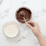 dipping a chocolate cake truffle in melted chocolate.