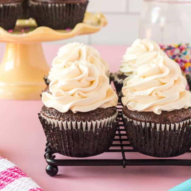 a group of cupcakes with white frosting on top.