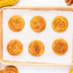 6 baked pumpkin snickerdoodle cookies on a baking sheet.