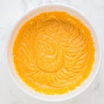 orange batter in a white bowl.