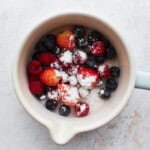 Fresh berries and sugar in a saucepan.