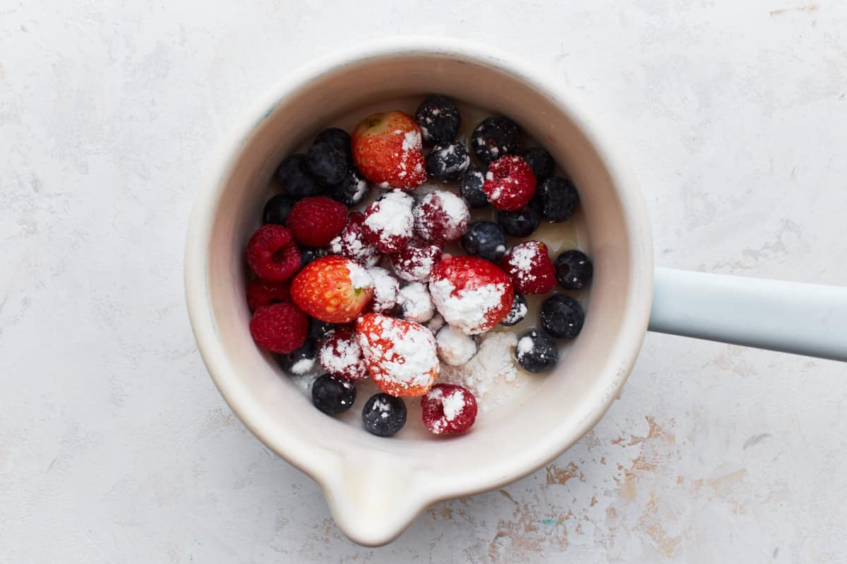 Fresh berries and sugar in a saucepan.