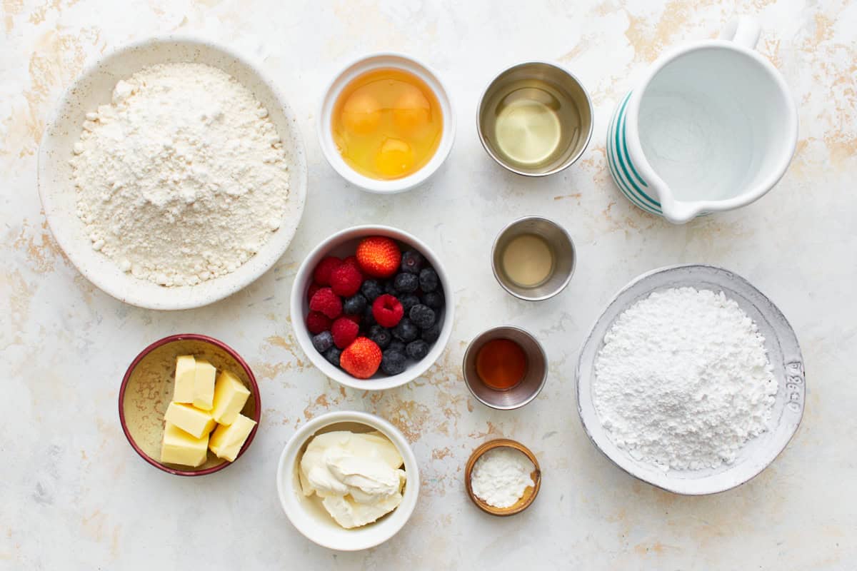 Ingredients for Berry-filled cupcakes arranged in dishes.