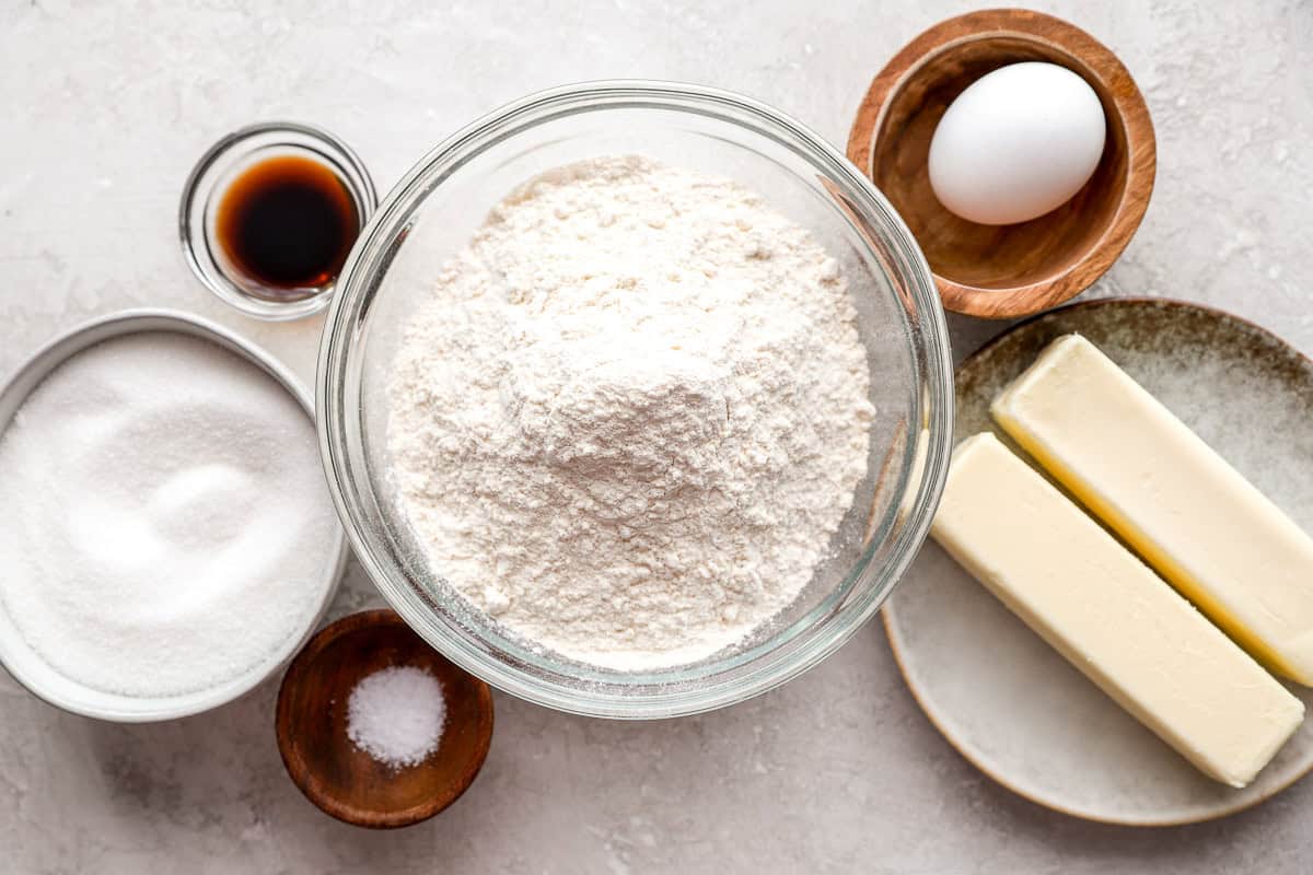 Ingredients for butter cookies arranged in dishes.