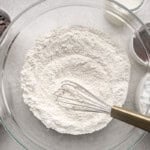 Dry ingredients in a mixing bowl with a whisk.