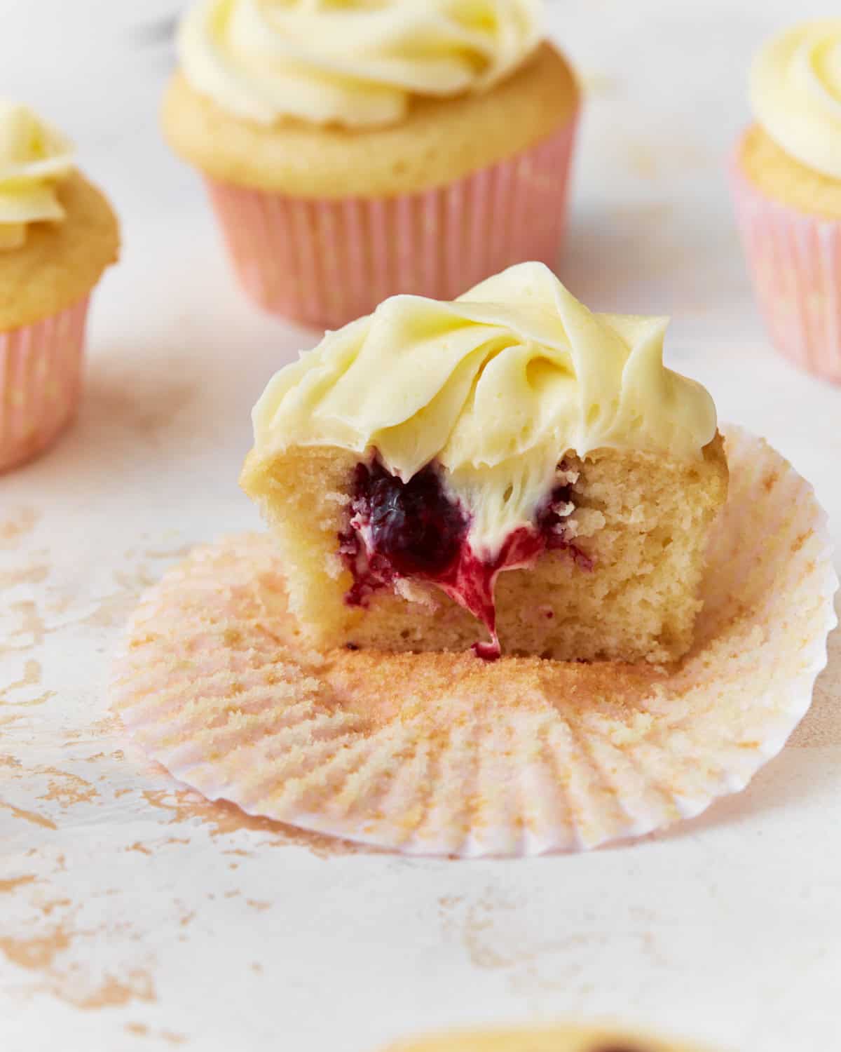 berry filled cupcake with vanilla frosting