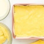 thick lemon cake batter pressed into the bottom of a square baking pan.