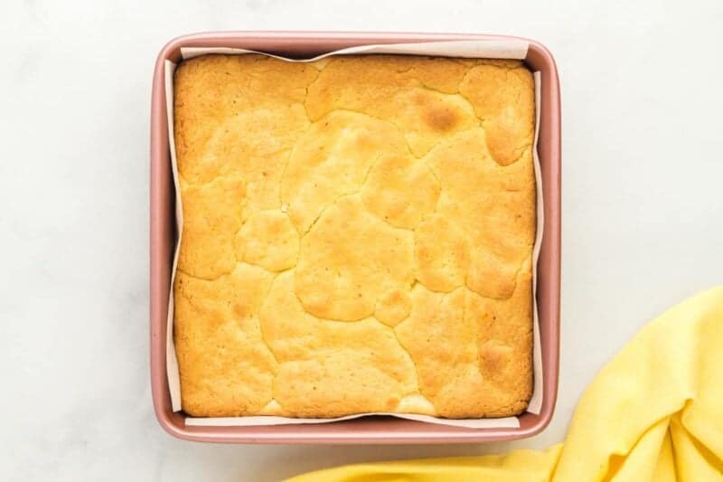 baked lemon cake bars in a square baking pan.