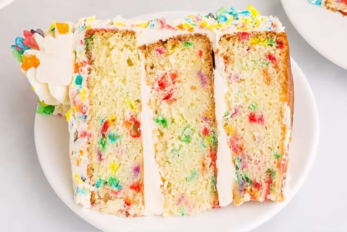 a slice of fruity pebbles cake on a plate.