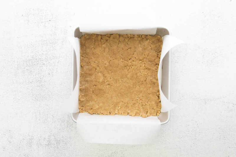 brown sugar shortbread crust pressed into a lined square baking pan.