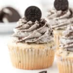 a frosted cookies and cream cupcake topped with Oreo crumbs and a mini Oreo cookie.