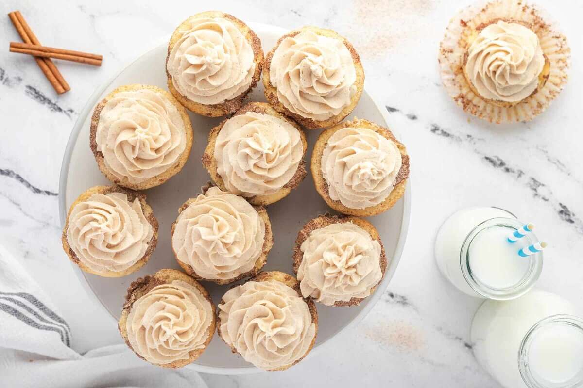 overhead view of frosted snickerdoodle cupcakes on a plate.