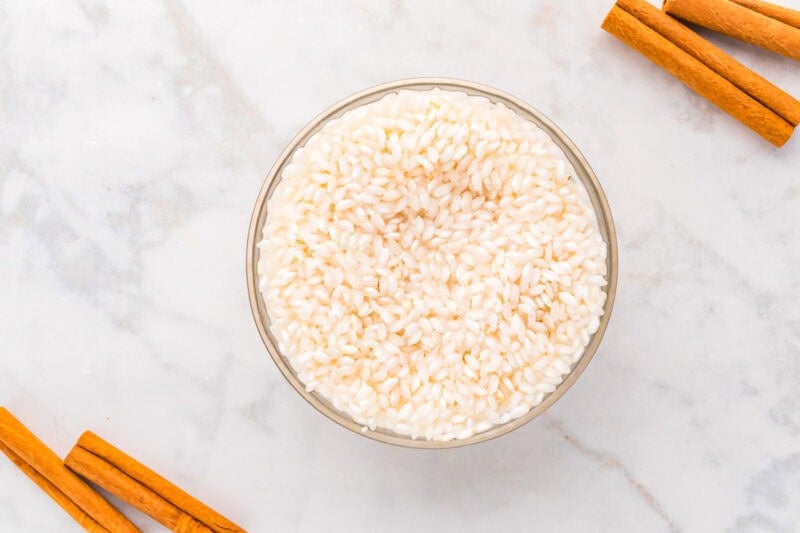 rinsed uncooked arborio rice in a glass bowl.