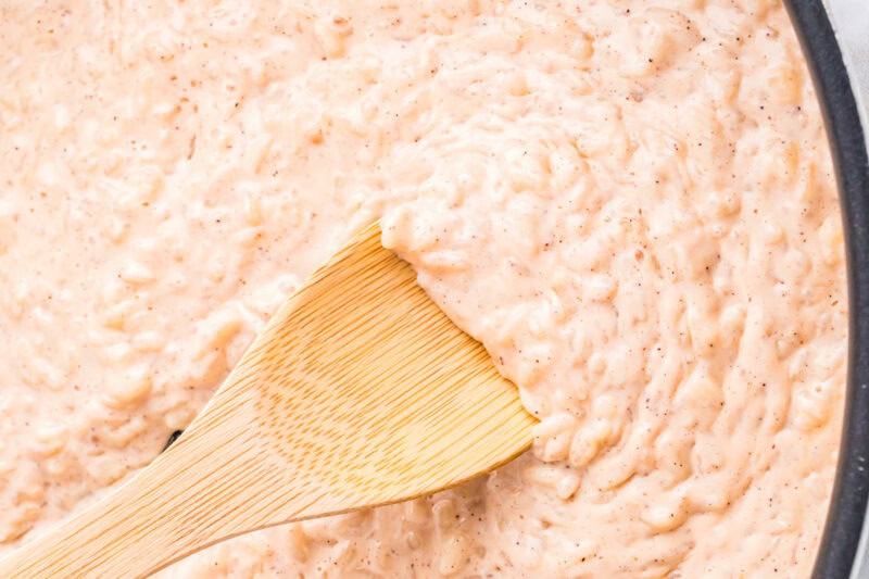 closeup of cooked rice pudding with a wooden spoon.