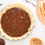 german chocolate pie filling poured over a par-baked pie crust in a pie pan.