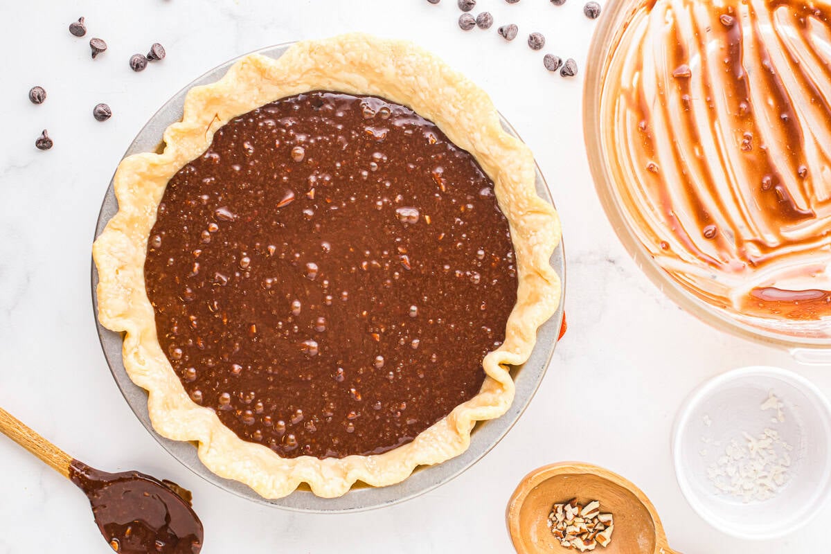 german chocolate pie filling poured over a par-baked pie crust in a pie pan.