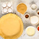 portioned ingredients for vinegar pie filling next to a crimped pie crust in a pie pan.