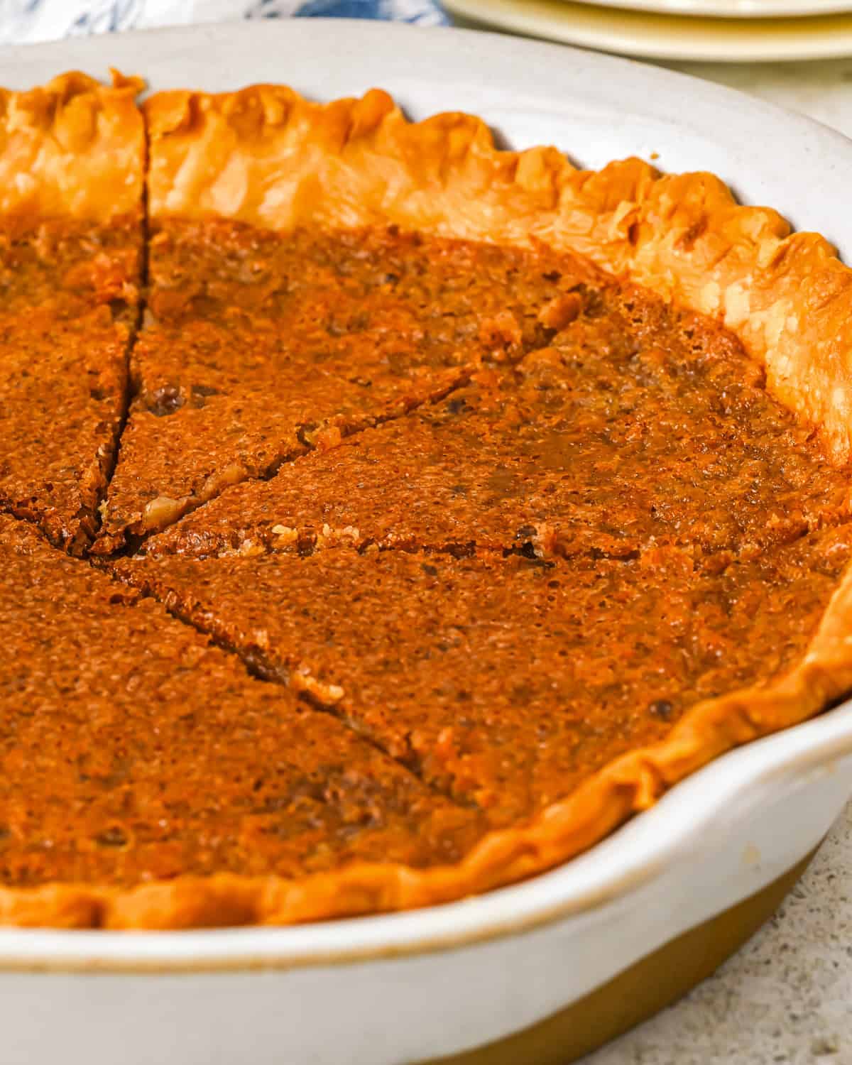 three-quarters partial view of a baked and sliced vinegar pie in a pie pan.