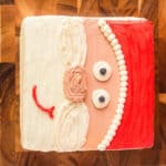 decorated santa cake on a wooden cutting board.