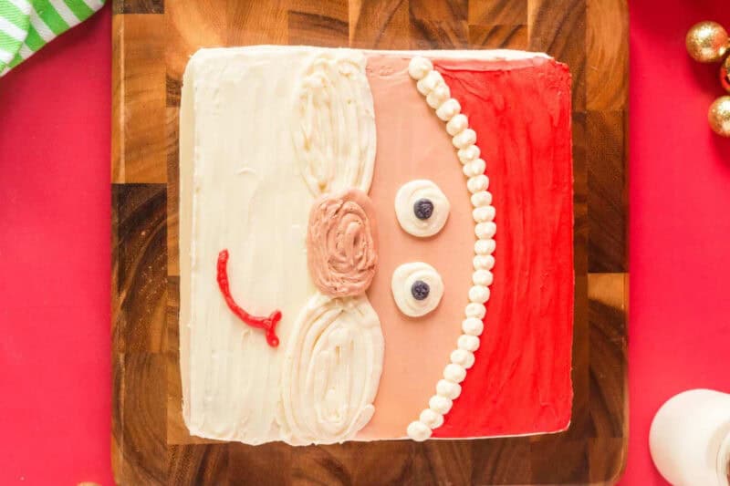 decorated santa cake on a wooden cutting board.