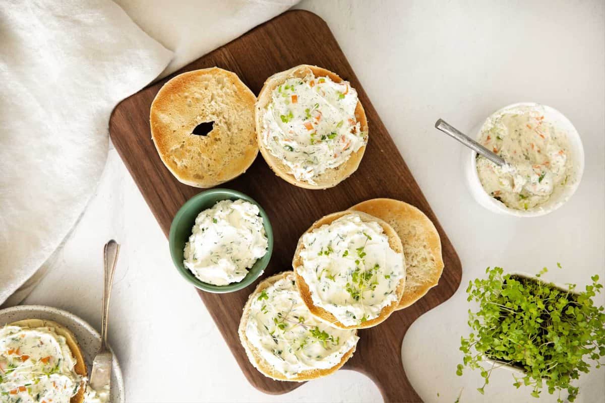 Homemade cream cheese flavors spread on sliced bagels.