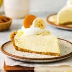 a slice of banana pudding pie topped with whipped cream, a nilla wafer, and a banana slice.