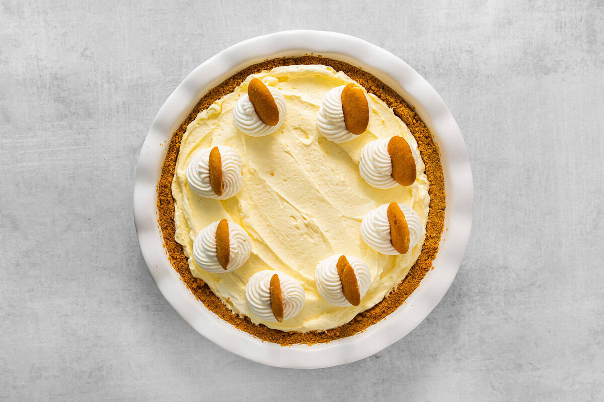 banana pudding pie topped with whipped cream and vanilla wafers.