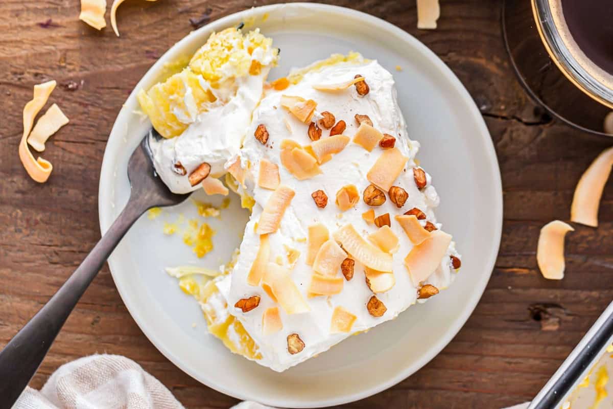 overhead view of a slice of partially eaten twinkie cake on a plate with a fork.