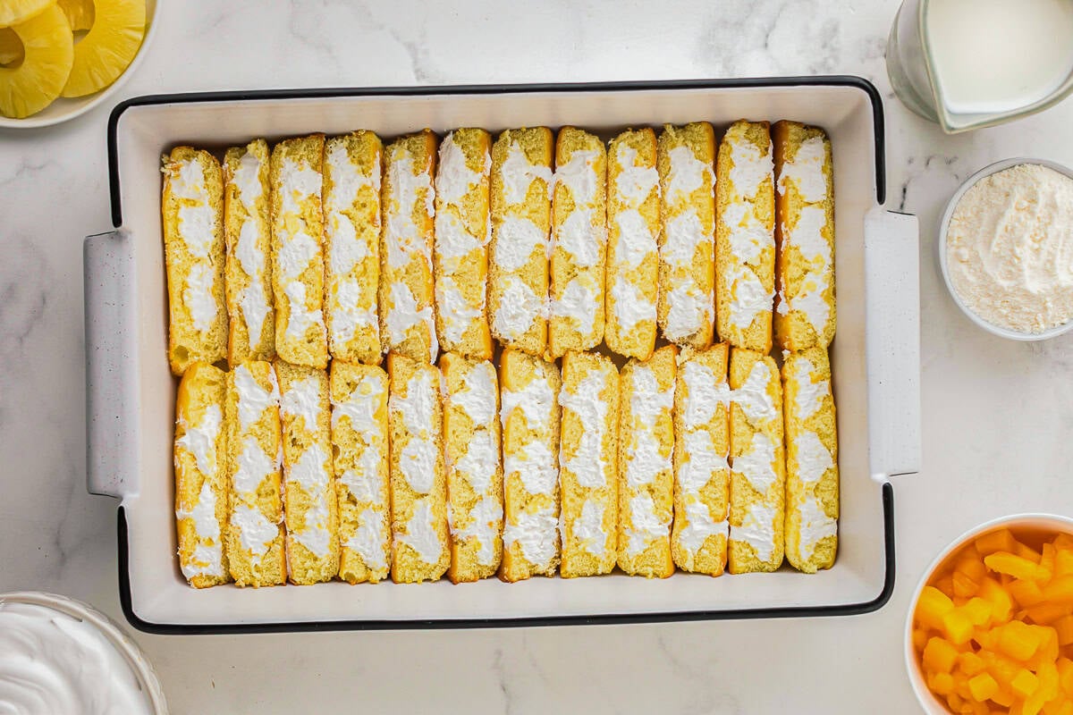 halved twinkies arranged filling-side-up in a baking pan.