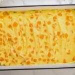 mango pudding mixture spread over twinkies in a baking dish.