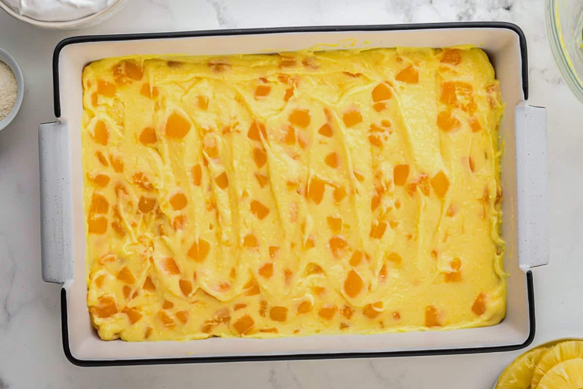 mango pudding mixture spread over twinkies in a baking dish.