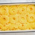 pineapple rings over mango pudding in a baking dish.