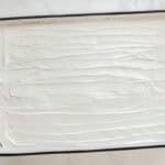 whipped topping spread over twinkie cake in a cake pan.