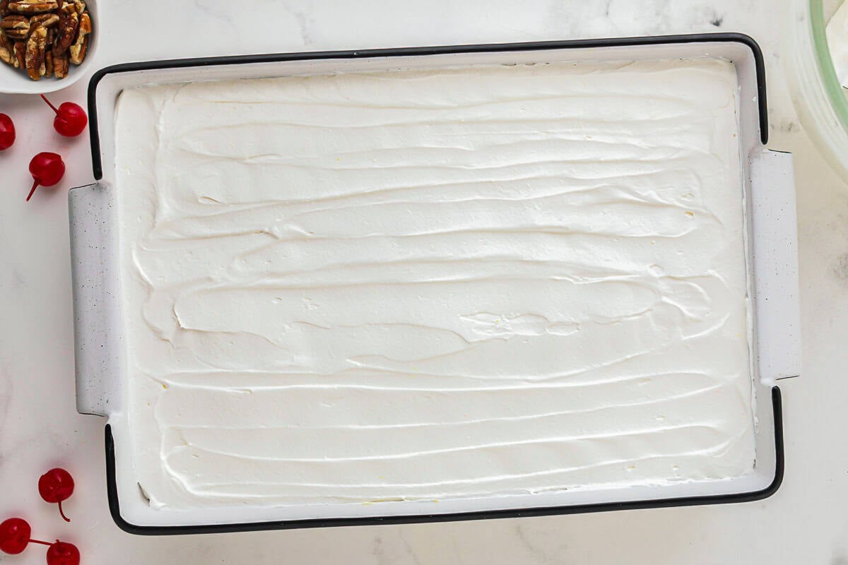 whipped topping spread over twinkie cake in a cake pan.