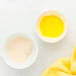 a larger bowl filled with white creme filling next to a smaller bowl filled with yellow creme filling.