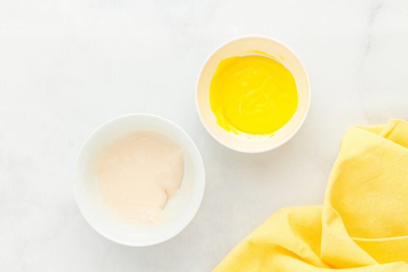 a larger bowl filled with white creme filling next to a smaller bowl filled with yellow creme filling.