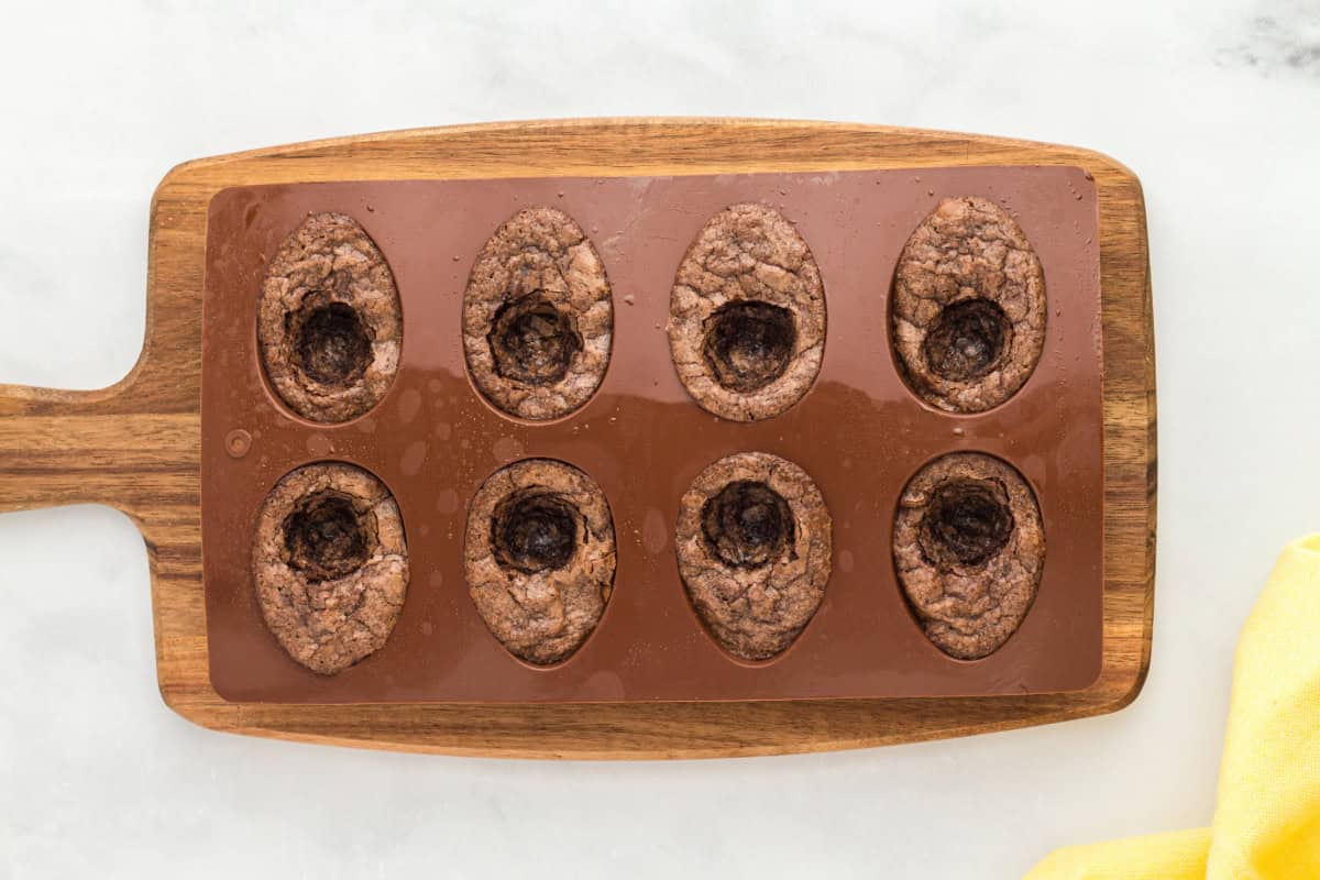 baked brownies with a yolk-shaped circle scooped out of the center in a silicone mold.